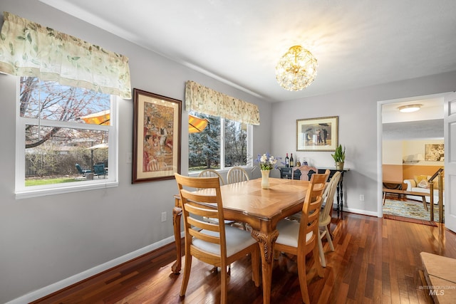 dining room featuring wood-type flooring, an inviting chandelier, and baseboards