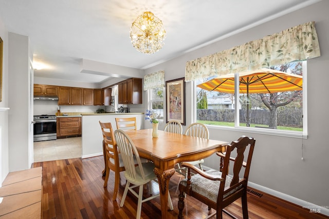 dining area with a notable chandelier, baseboards, light wood-style floors, and visible vents