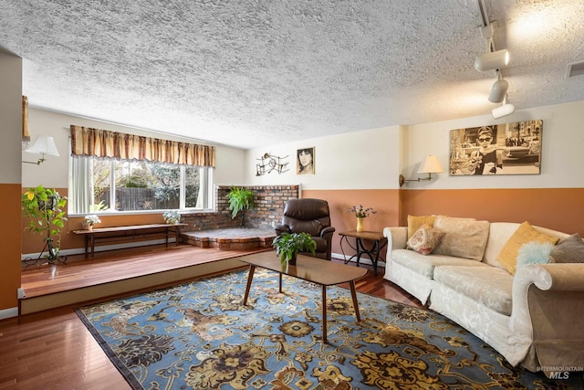 living room featuring visible vents, track lighting, a textured ceiling, and wood finished floors