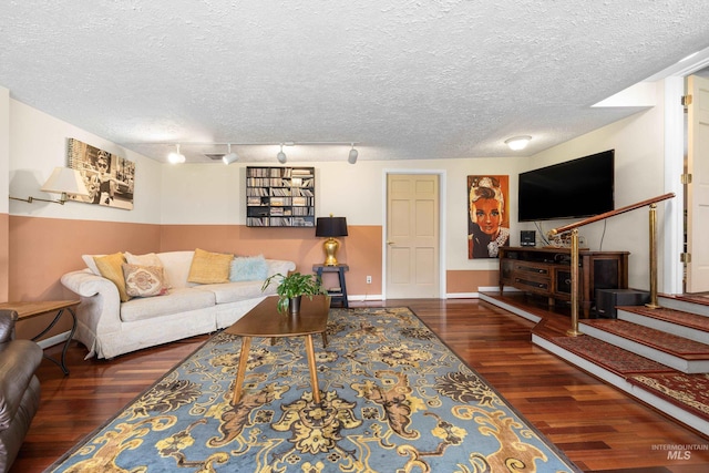 living room with a textured ceiling, baseboards, stairs, and wood finished floors