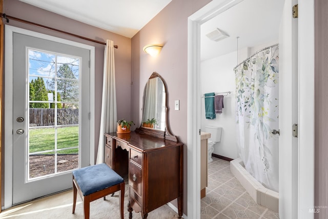 bathroom with a shower with curtain, toilet, and baseboards
