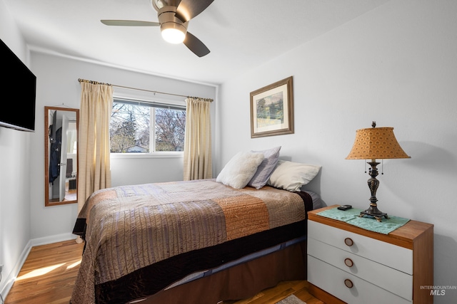 bedroom with baseboards, ceiling fan, and wood finished floors