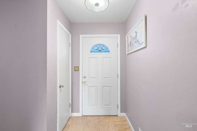 doorway to outside with light tile patterned floors and baseboards