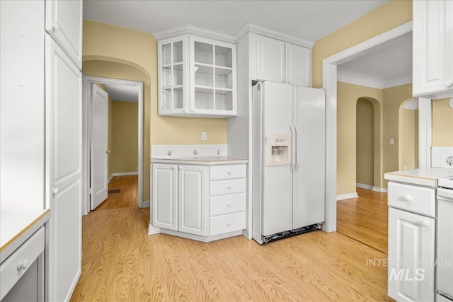 3205 W Crescent Rim Dr, Boise, ID 83706 - kitchen featuring white refrigerator with ice dispenser, arched walkways, light countertops, and light wood-style flooring