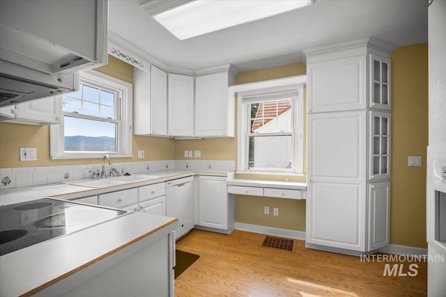3205 W Crescent Rim Dr, Boise, ID 83706 - kitchen with dishwasher, a sink, white cabinets, light wood finished floors, and light countertops