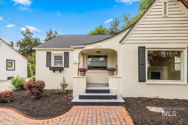 3205 W Crescent Rim Dr, Boise, ID 83706 - doorway to property featuring a shingled roof and stucco siding