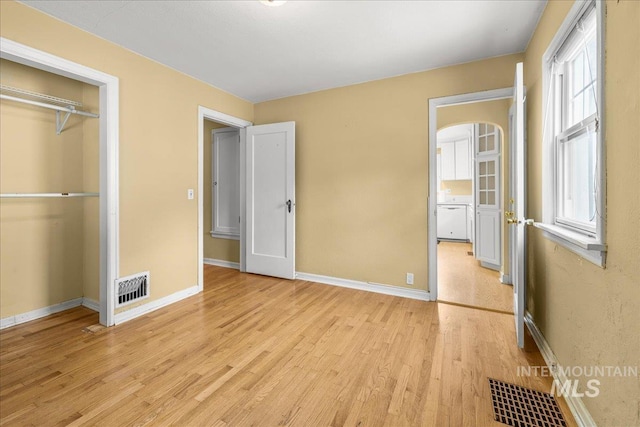 3205 W Crescent Rim Dr, Boise, ID 83706 - unfurnished bedroom featuring light wood-style flooring, baseboards, arched walkways, and a closet