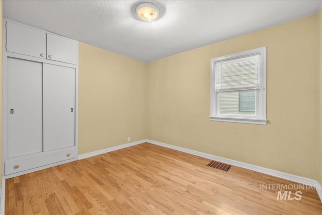 3205 W Crescent Rim Dr, Boise, ID 83706 - unfurnished bedroom with baseboards, light wood-type flooring, and a closet