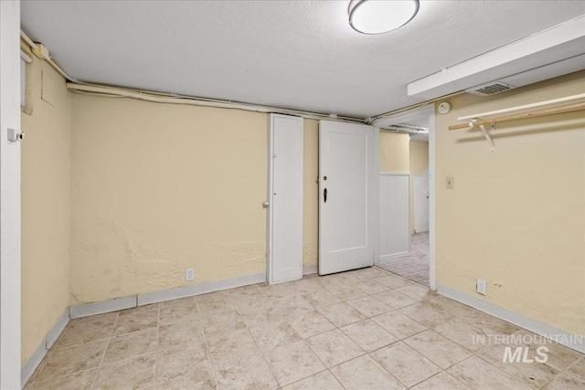 3205 W Crescent Rim Dr, Boise, ID 83706 - finished below grade area featuring baseboards, a textured ceiling, and tile patterned floors