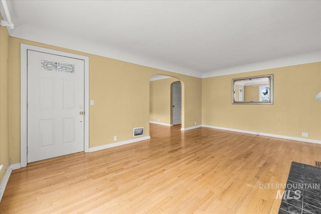 3205 W Crescent Rim Dr, Boise, ID 83706 - empty room featuring arched walkways, light wood-style floors, and baseboards