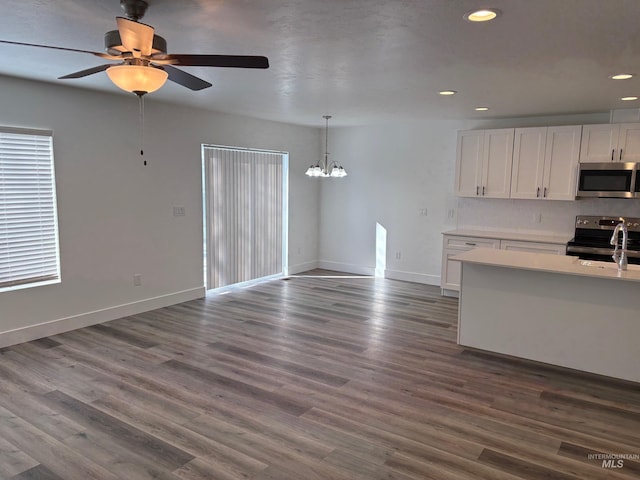 kitchen with white cabinetry, decorative light fixtures, dark wood-type flooring, and appliances with stainless steel finishes