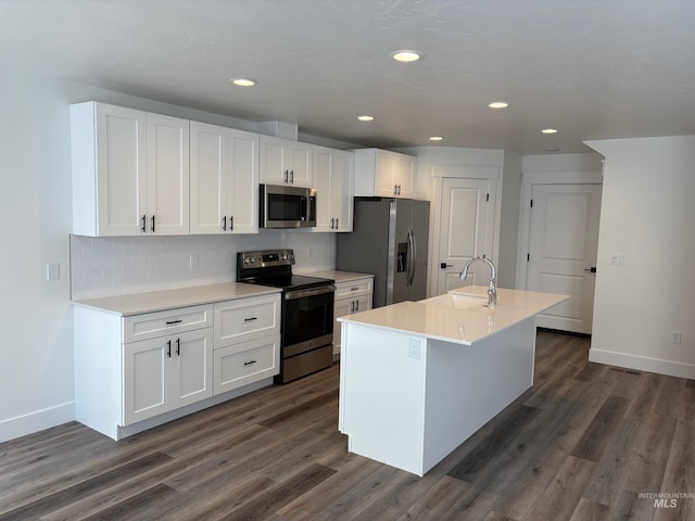 kitchen with white cabinetry, appliances with stainless steel finishes, a kitchen island with sink, and sink