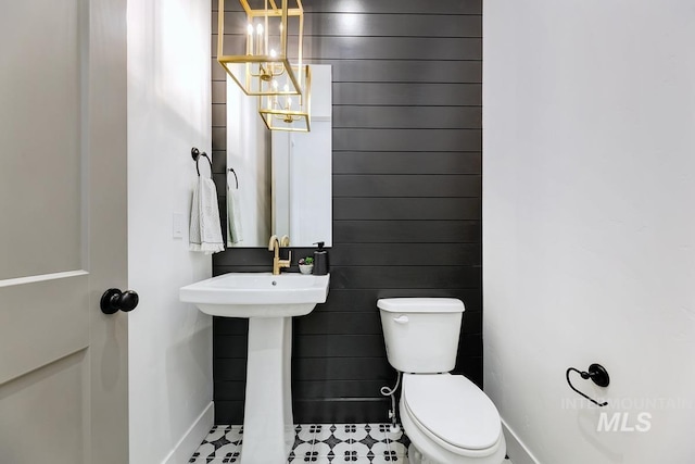 bathroom featuring a notable chandelier and toilet