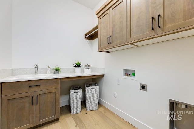 laundry area featuring cabinets, sink, washer hookup, light wood-type flooring, and hookup for an electric dryer