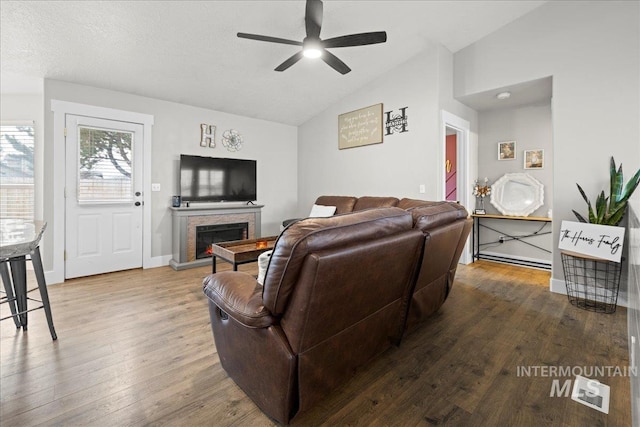 535 Seasons Ct, Nampa, ID 83686 - living area with lofted ceiling, a ceiling fan, a stone fireplace, wood finished floors, and baseboards
