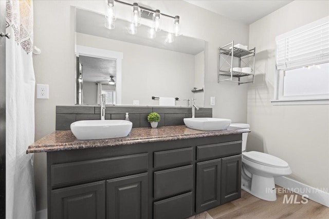 535 Seasons Ct, Nampa, ID 83686 - full bath with double vanity, wood finished floors, toilet, ceiling fan, and baseboards