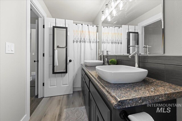 535 Seasons Ct, Nampa, ID 83686 - full bathroom with wood finished floors, double vanity, and decorative backsplash