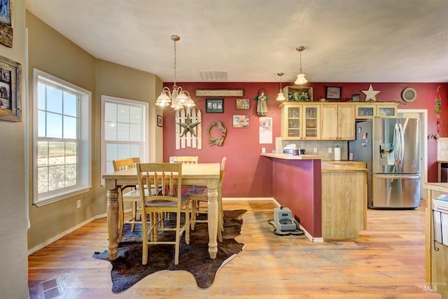 28284 Tudie Ln, Parma, ID 83660 - dining space featuring a chandelier, light wood-style floors, visible vents, and baseboards