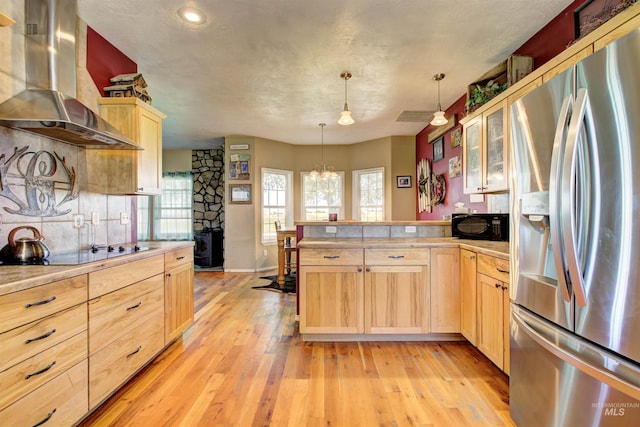 28284 Tudie Ln, Parma, ID 83660 - kitchen featuring a peninsula, wall chimney exhaust hood, light brown cabinets, and black appliances