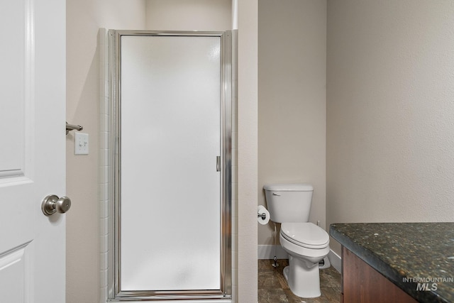 full bath with toilet, a shower stall, baseboards, and vanity