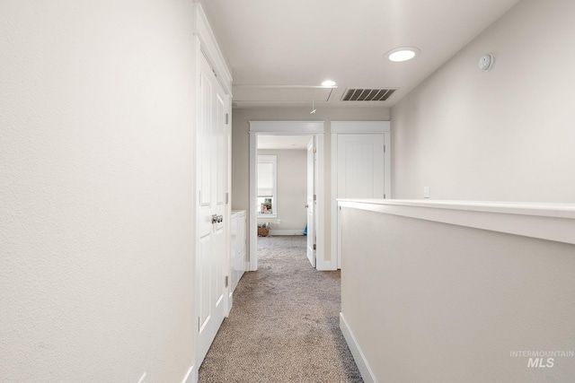 hallway featuring recessed lighting, visible vents, attic access, carpet flooring, and baseboards