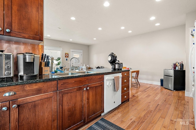 kitchen with light wood-style flooring, a peninsula, white dishwasher, a sink, and recessed lighting