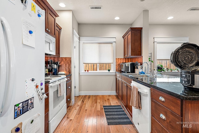 kitchen with white appliances, visible vents, a wealth of natural light, and a sink