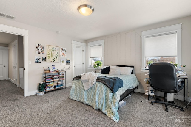 carpeted bedroom with visible vents and baseboards