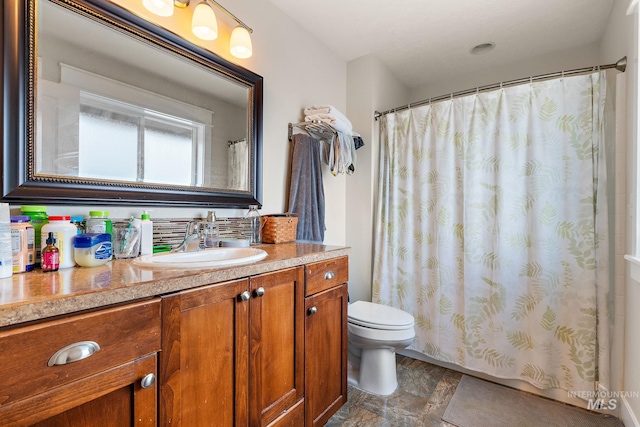 bathroom featuring toilet, a shower with shower curtain, and vanity