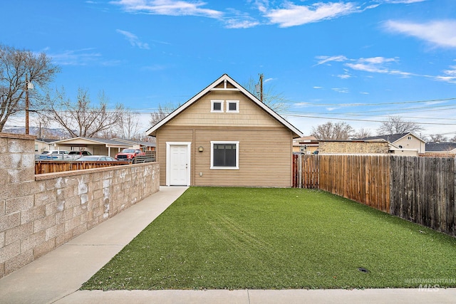 rear view of property with a lawn and fence