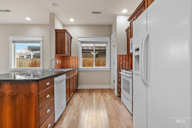 kitchen featuring white appliances, plenty of natural light, visible vents, and a sink