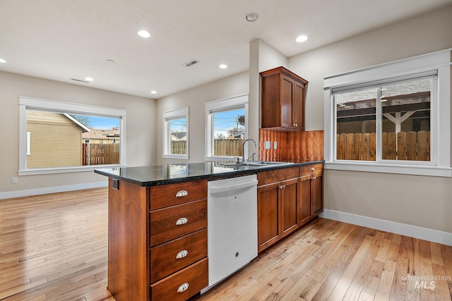 kitchen with a sink, light wood-style flooring, a peninsula, and dishwasher