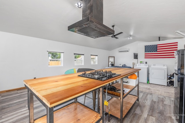 205 N Fouch, Parma, ID 83660 - kitchen featuring island exhaust hood, gas stovetop, wood finished floors, a wall unit AC, and vaulted ceiling