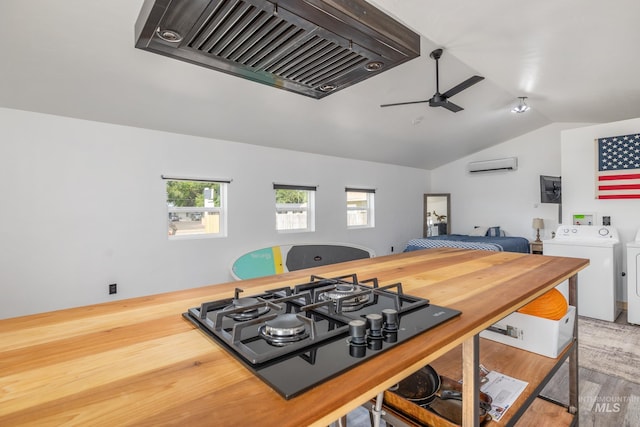 205 N Fouch, Parma, ID 83660 - kitchen with washer and clothes dryer, custom range hood, a wall mounted AC, a ceiling fan, and vaulted ceiling