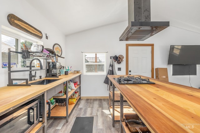 205 N Fouch, Parma, ID 83660 - kitchen featuring exhaust hood, butcher block counters, stainless steel microwave, lofted ceiling, and light wood-type flooring