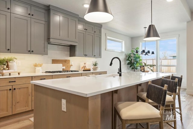 kitchen featuring gray cabinetry, light wood-type flooring, and gas cooktop