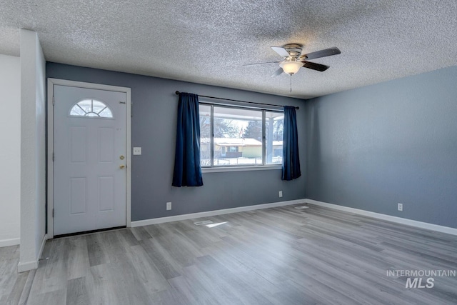 entryway with ceiling fan, a textured ceiling, and light hardwood / wood-style flooring