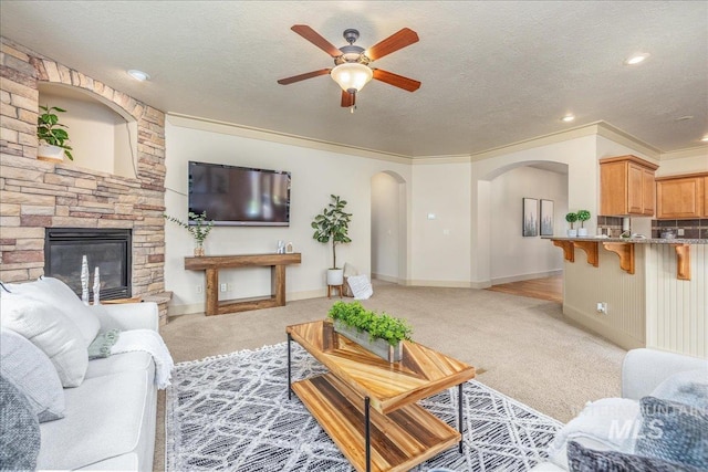 2895 E Shadowwolf Dr, Eagle, ID 83616 - living room with ceiling fan, light colored carpet, arched walkways, a fireplace, and a textured ceiling