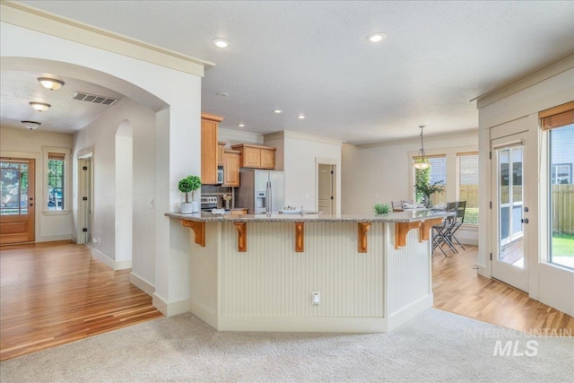 2895 E Shadowwolf Dr, Eagle, ID 83616 - kitchen featuring stainless steel appliances, light carpet, a breakfast bar, and recessed lighting