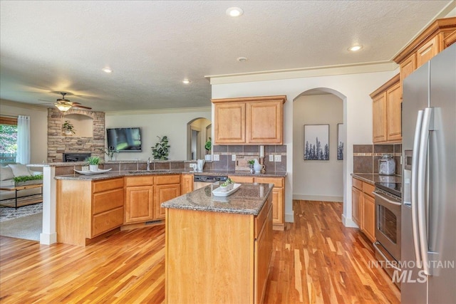 2895 E Shadowwolf Dr, Eagle, ID 83616 - kitchen with stainless steel appliances, arched walkways, a peninsula, open floor plan, and ornamental molding