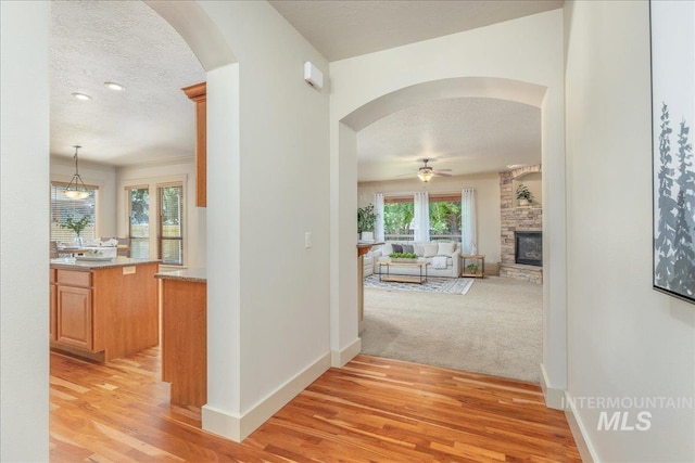 2895 E Shadowwolf Dr, Eagle, ID 83616 - hall featuring arched walkways, light wood-style flooring, and a textured ceiling