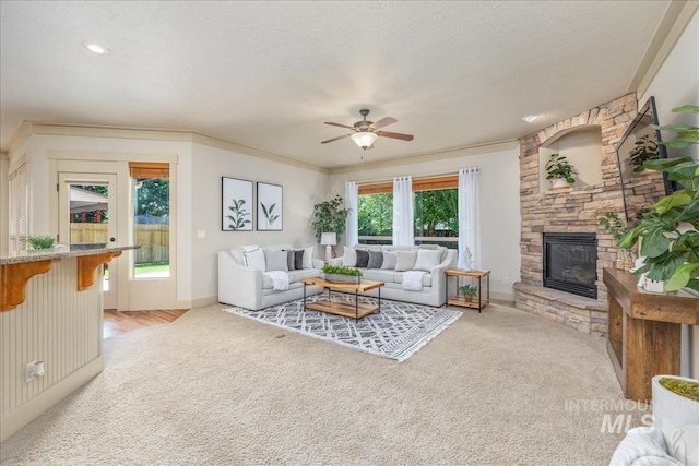 2895 E Shadowwolf Dr, Eagle, ID 83616 - living area featuring light carpet, a stone fireplace, a ceiling fan, crown molding, and a textured ceiling