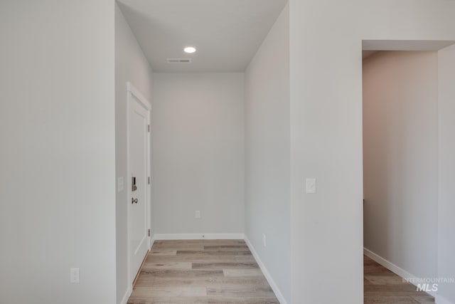 hallway with recessed lighting, baseboards, visible vents, and light wood finished floors