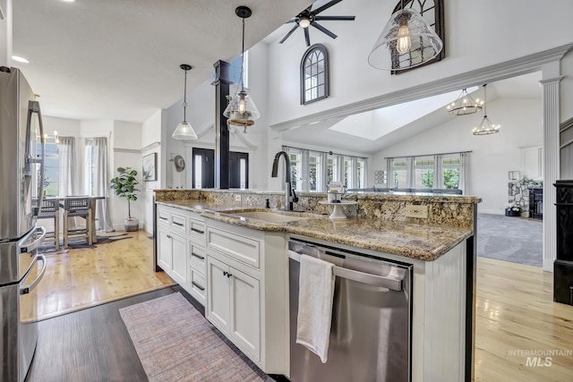 930 W Wanda Ln, Heyburn, ID 83336 - kitchen featuring stainless steel appliances, a sink, open floor plan, light stone counters, and decorative light fixtures