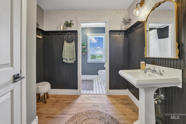 930 W Wanda Ln, Heyburn, ID 83336 - bathroom featuring wood finished floors, toilet, wallpapered walls, and baseboards