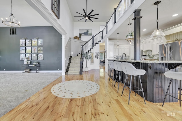 930 W Wanda Ln, Heyburn, ID 83336 - kitchen featuring a high ceiling, a chandelier, white cabinets, light wood-type flooring, and a breakfast bar