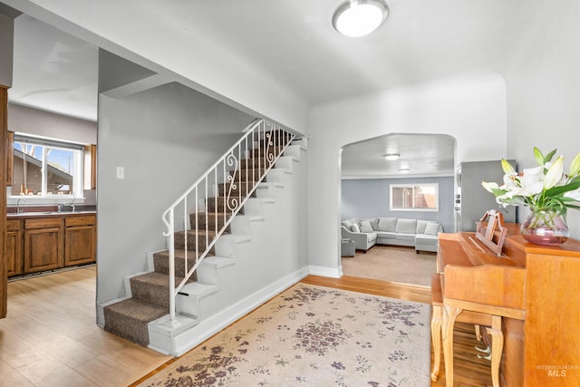 stairs featuring sink and wood-type flooring