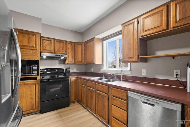 kitchen featuring stainless steel appliances, sink, and light hardwood / wood-style flooring