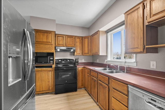 kitchen with sink, light hardwood / wood-style flooring, and black appliances