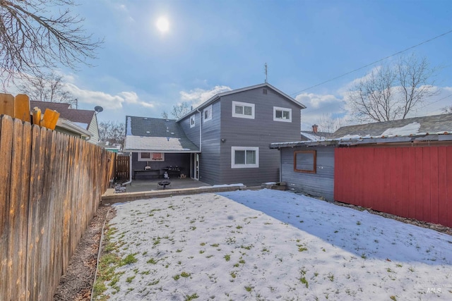 snow covered rear of property featuring a patio area